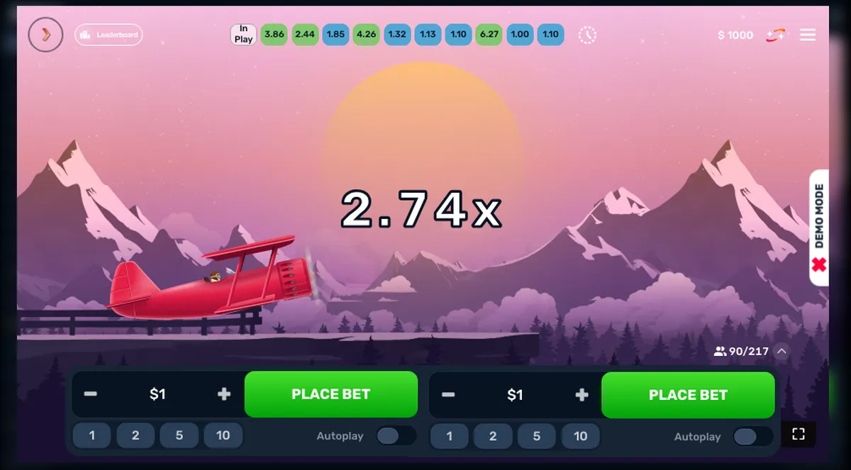 Captura del modo demo de Aero: el biplano rojo volando entre montañas con el multiplicador en x2,74, la etiqueta DEMO MODE al costado y 90 de 217 jugadores conectados
